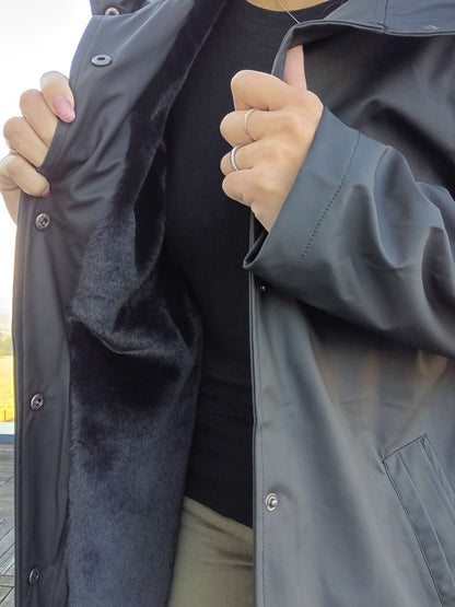 Person showing inside of black long waterproof coat with faux fur lining, Le Petit Placard