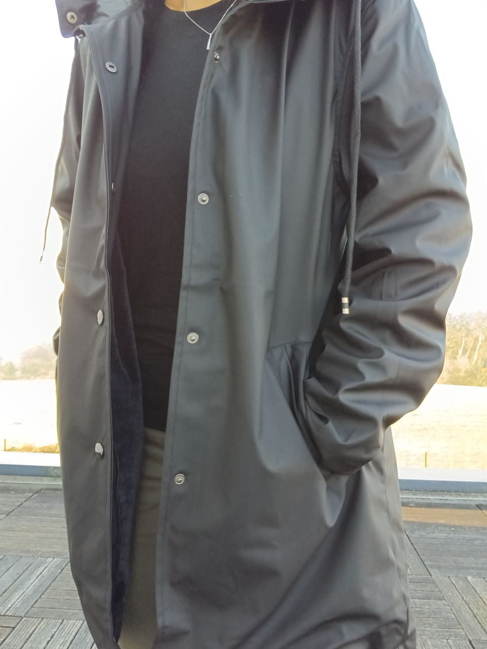 Black long waterproof Laura Jo raincoat with fleece lining, worn outdoors, Le Petit Placard