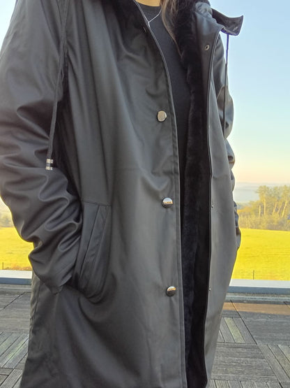 Long black waterproof coat with buttons, outdoor terrace, Le Petit Placard collection.