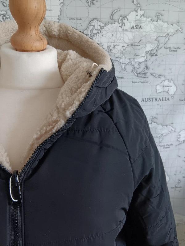 Reversible black and beige faux shearling hooded raincoat on mannequin, Le Petit Placard