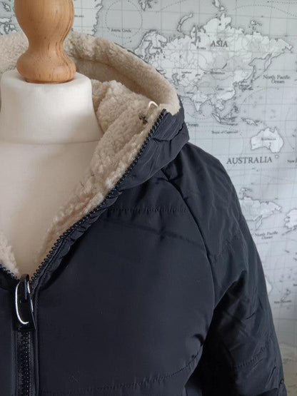 Reversible black and beige faux shearling hooded raincoat on mannequin, Le Petit Placard