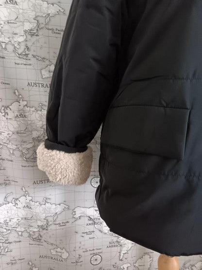 Black reversible waterproof short coat with faux shearling cuff by Le Petit Placard
