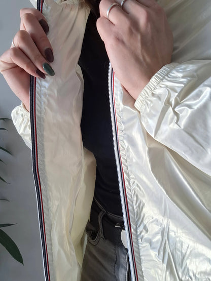 Woman wearing shiny white Laura Jo raincoat, black top, grey pants, Le Petit Placard fashion