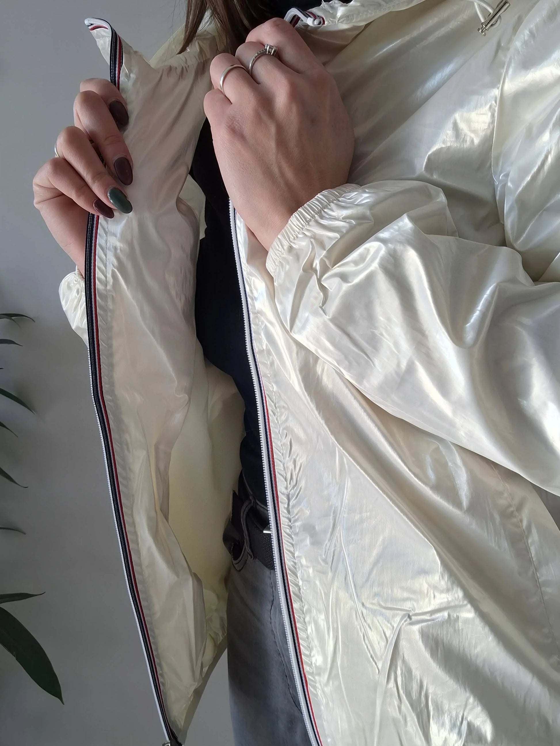 Close-up of woman wearing shiny cream Laura Jo raincoat from Le Petit Placard