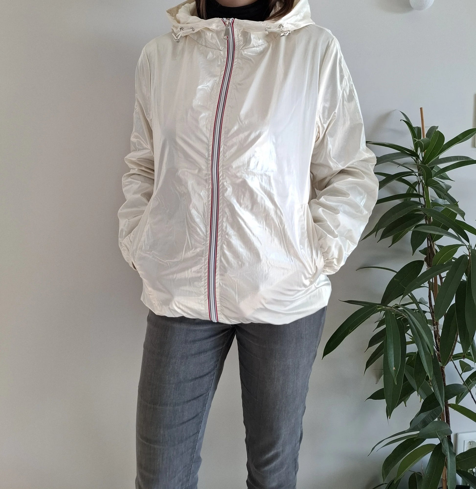 Woman wearing a shiny white Laura Jo raincoat with striped zipper, casual outfit, indoor plant