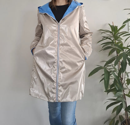 Manteau long réversible imperméable Melya Melody côté doré nacré avec capuche et intérieur bleu, porté par une femme