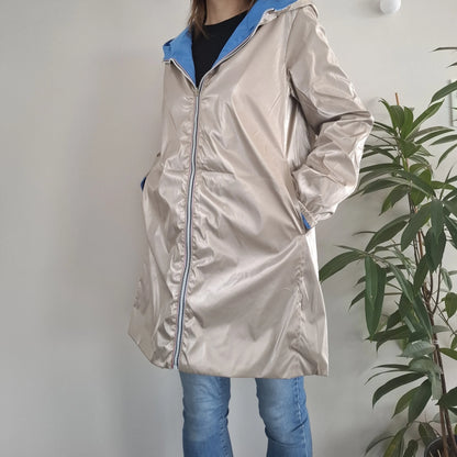 Manteau long réversible imperméable doré avec capuche bleue porté par une femme, Melya Melody