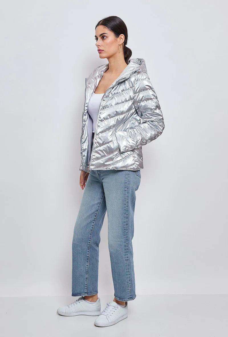 Woman wearing a silver quilted short jacket from Le Petit Placard, light jeans and sneakers