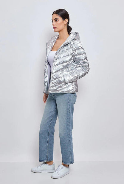 Woman wearing a silver quilted short jacket from Le Petit Placard, light jeans and sneakers