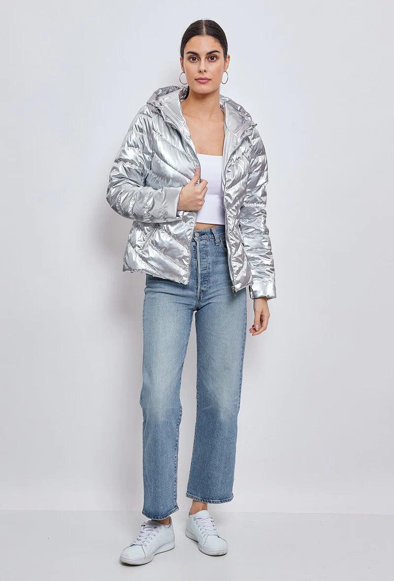 Woman wearing silver quilted cropped jacket, white crop top, blue jeans, Le Petit Placard fashion