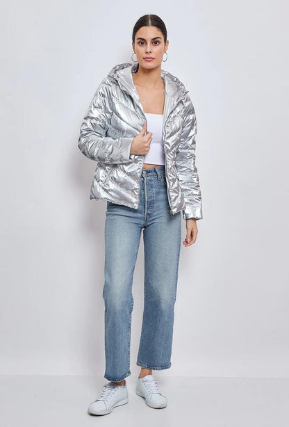 Woman wearing silver quilted cropped jacket, white crop top, blue jeans, Le Petit Placard fashion