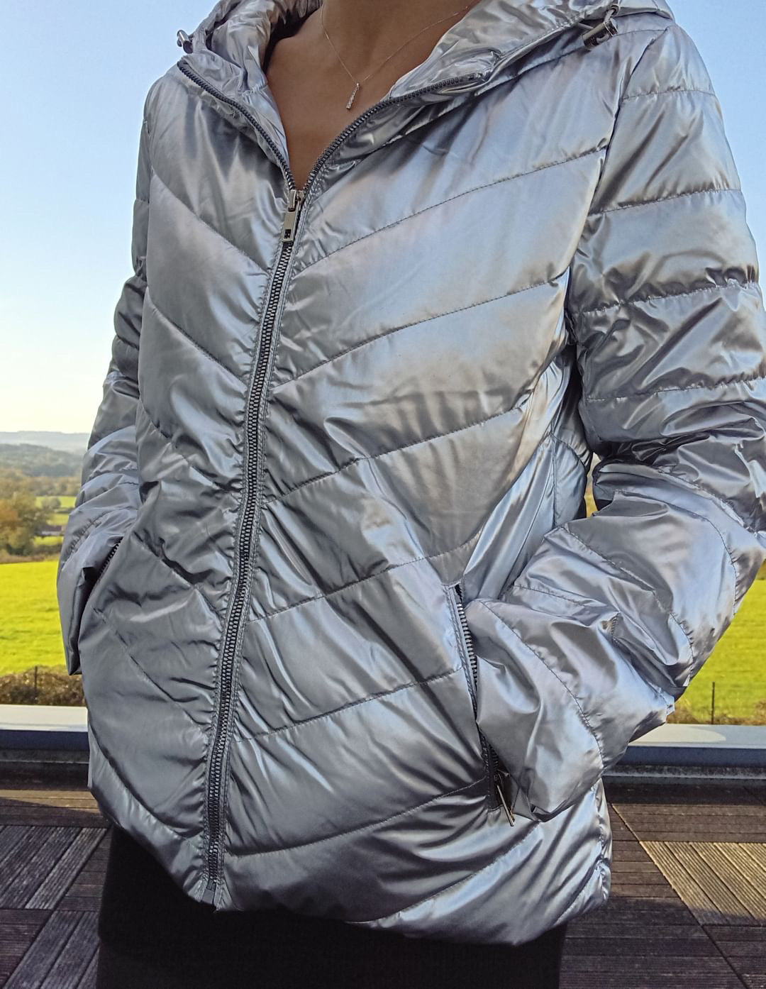 Shiny silver Laura Jo puffer jacket worn outdoors, featured by Le Petit Placard