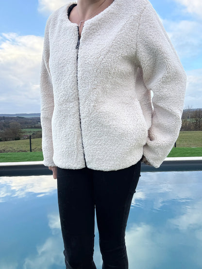 Veste courte réversible femme Laura Jo côté sherpa beige avec manches bouffantes, portée avec un jean noir