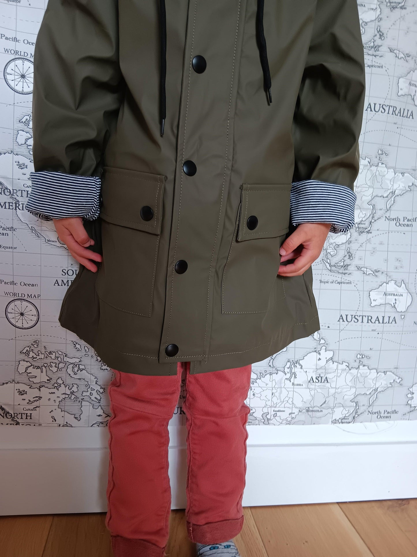 Child wearing khaki raincoat with striped cotton lining, fashion by Le Petit Placard