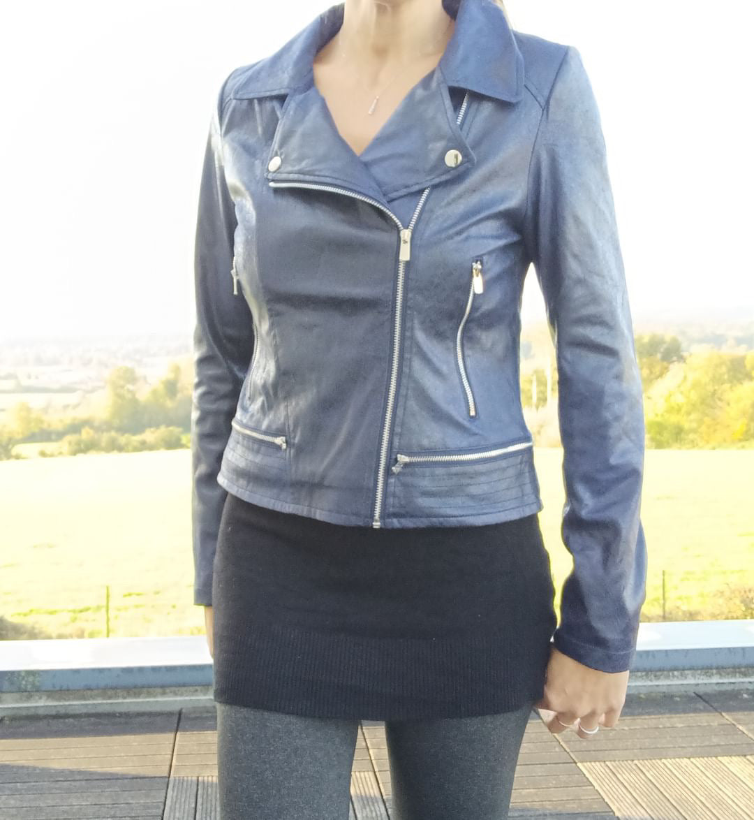 Woman wearing stylish blue faux leather jacket from Le Petit Placard outdoors