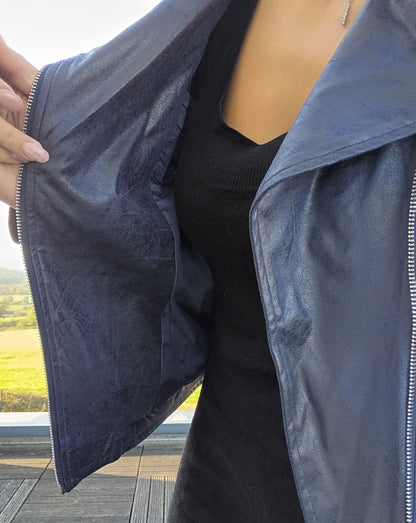 Woman wearing navy blue faux leather perfecto jacket from Le Petit Placard, outdoor setting