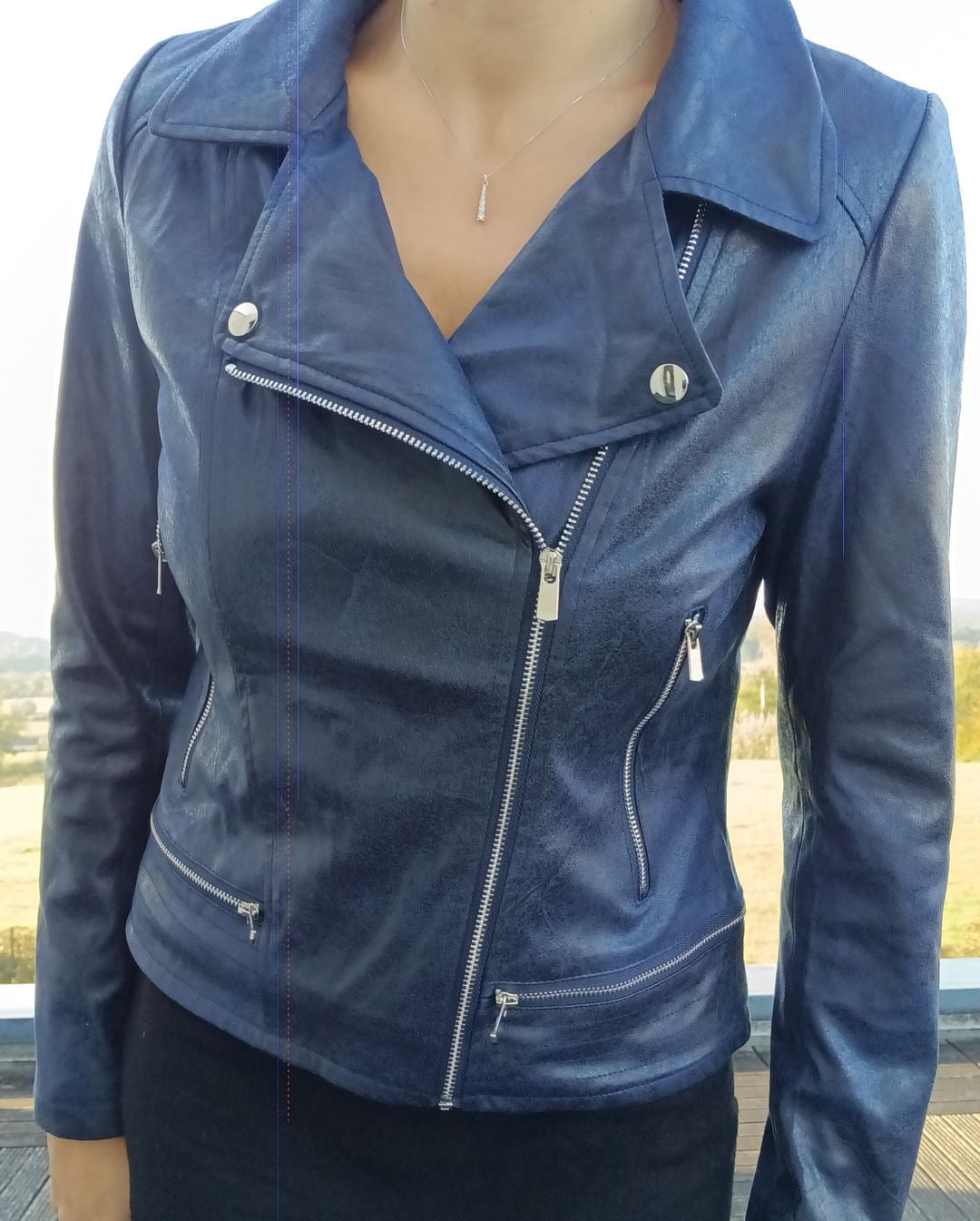 Woman wearing navy blue perfecto jacket with zippers from Le Petit Placard, outdoor setting