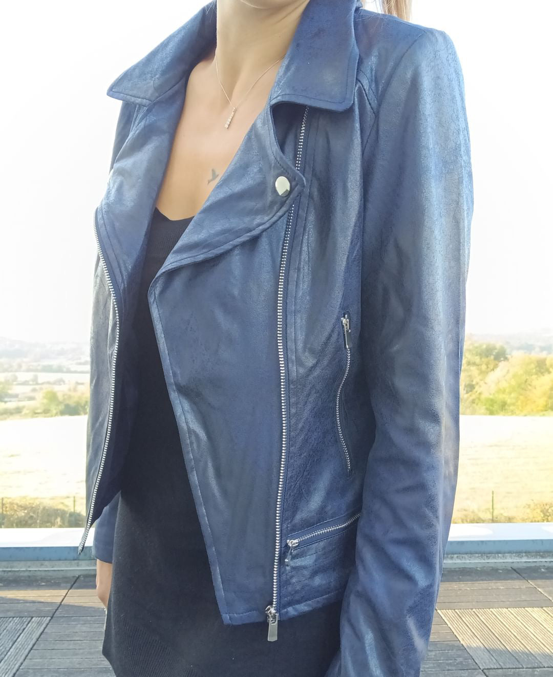 Woman wearing a navy blue perfecto jacket outdoors, Le Petit Placard fashion style