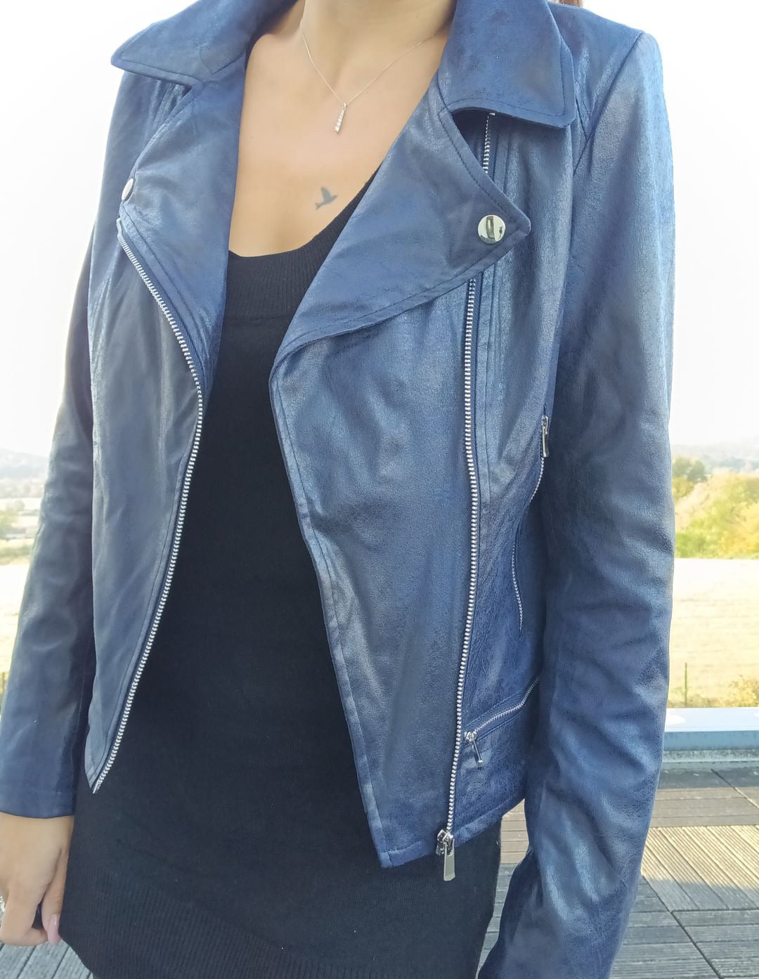 Woman wearing a navy blue perfecto jacket from Le Petit Placard outdoors