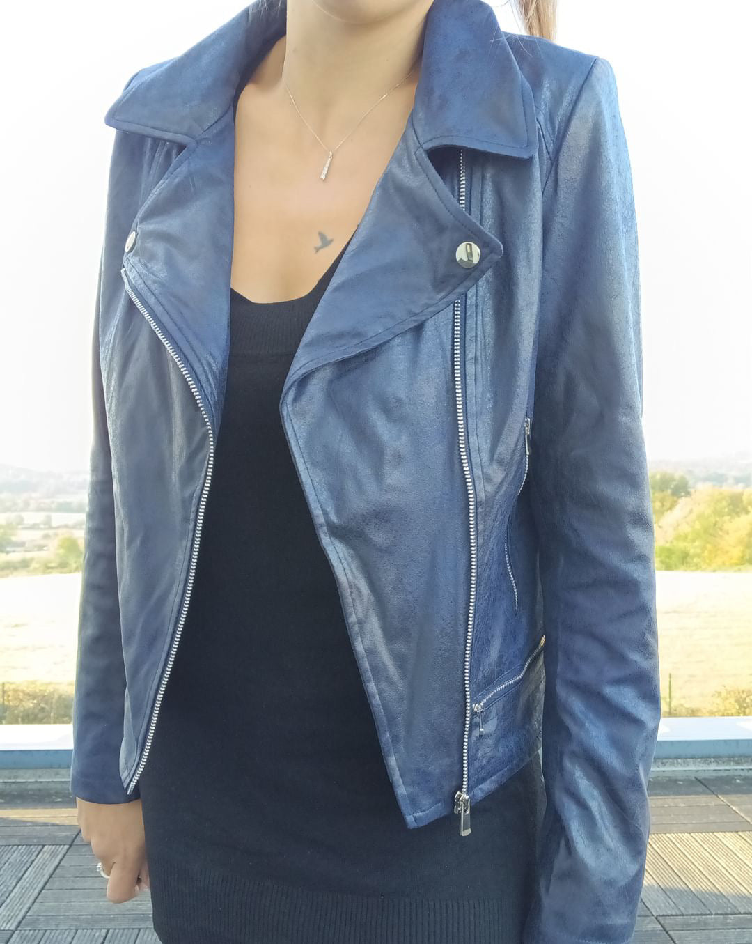 Woman wearing navy blue perfecto jacket from Le Petit Placard on terrace, fall fashion