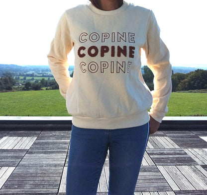 Woman in cream COPINE sweatshirt and jeans on terrace with scenic countryside view