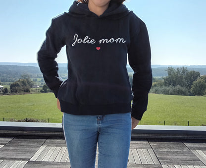 Woman wearing black 'Jolie mom' hoodie and jeans outdoors, Le Petit Placard fashion