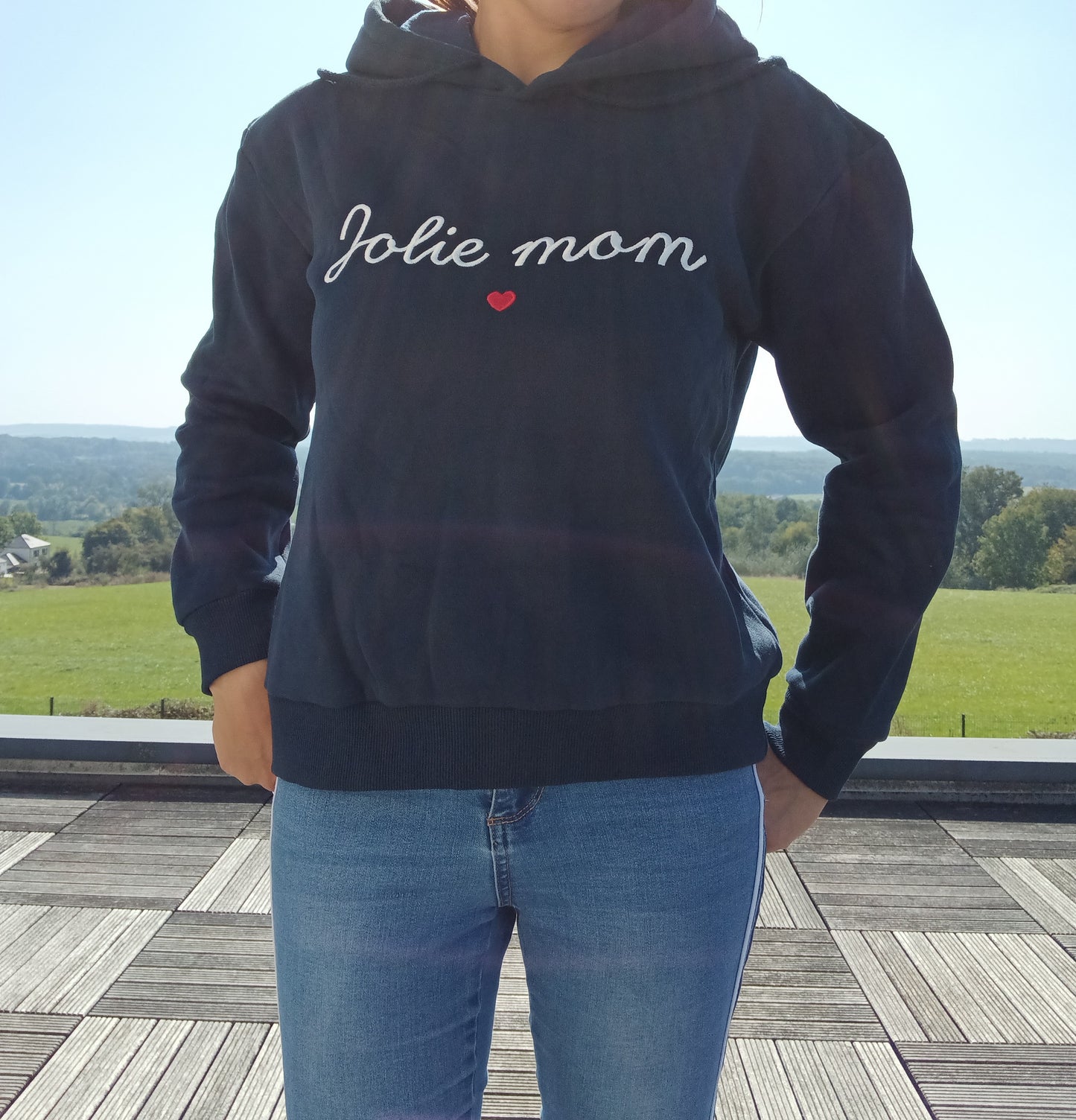 Woman wearing navy blue Jolie mom sweatshirt and jeans outdoors, Le Petit Placard