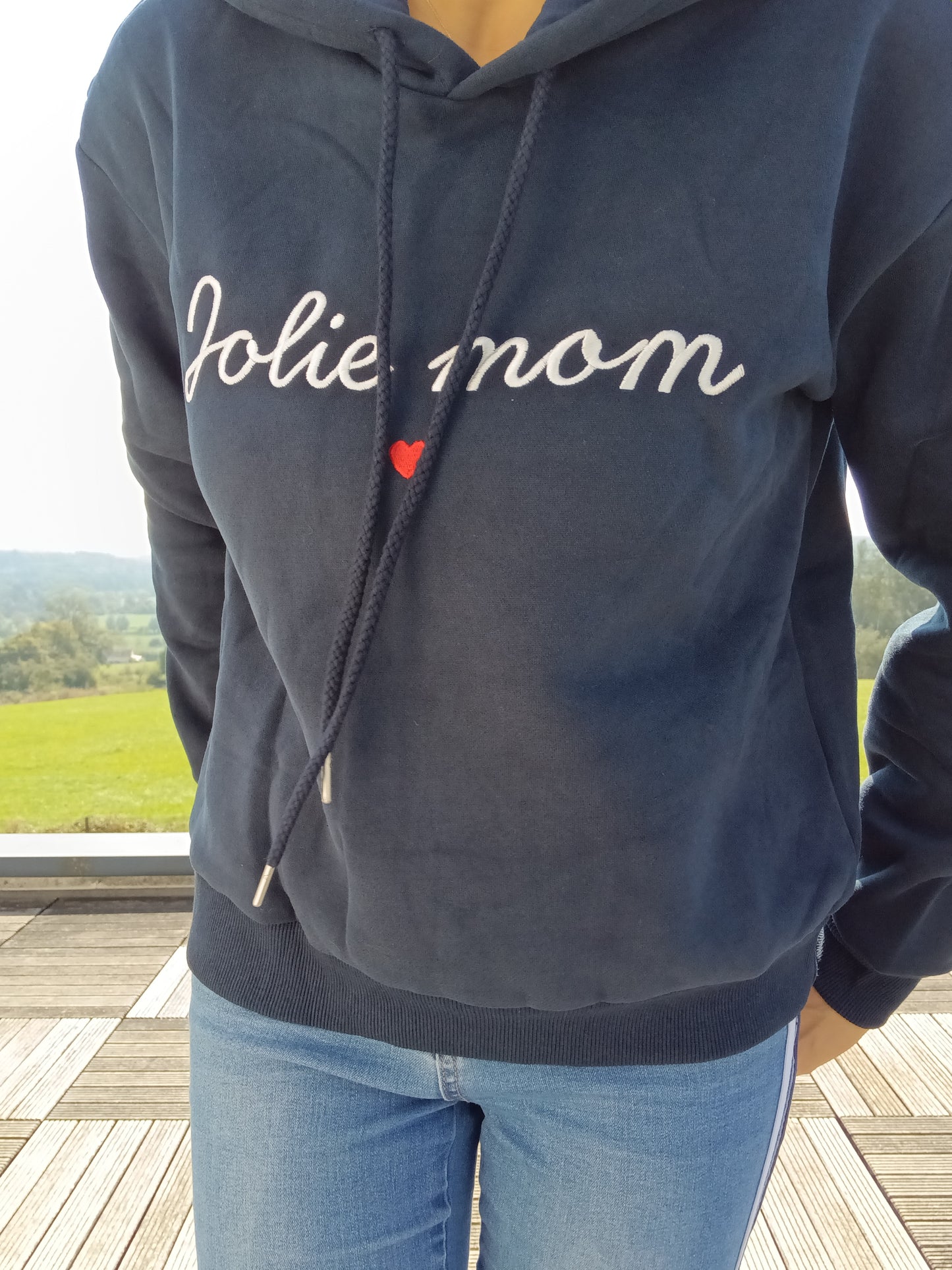 Navy blue hoodie with 'Jolie mom' embroidery, worn outdoors, Le Petit Placard fashion.