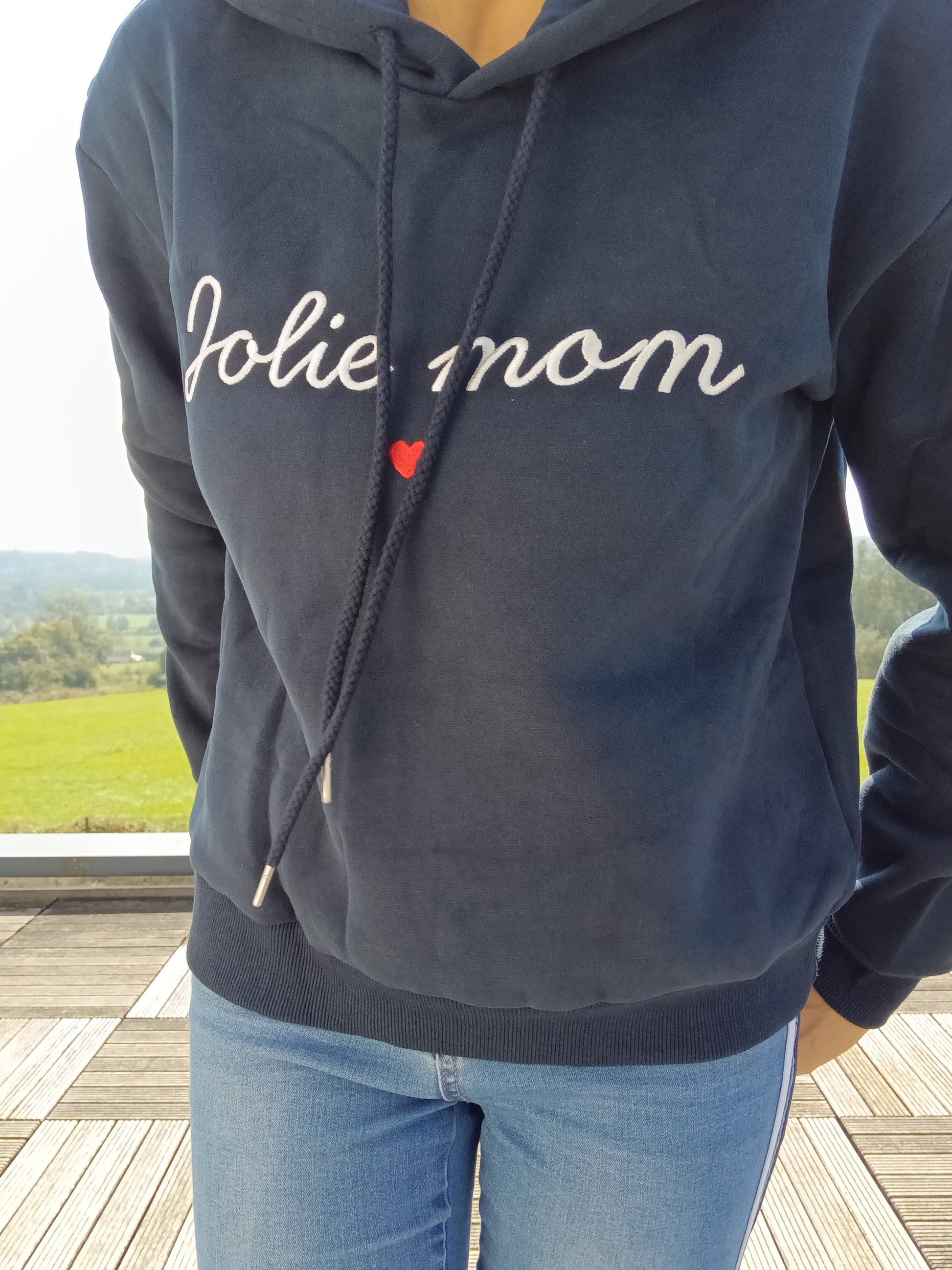 Navy blue hoodie with 'Jolie mom' embroidery, worn outdoors, Le Petit Placard fashion.