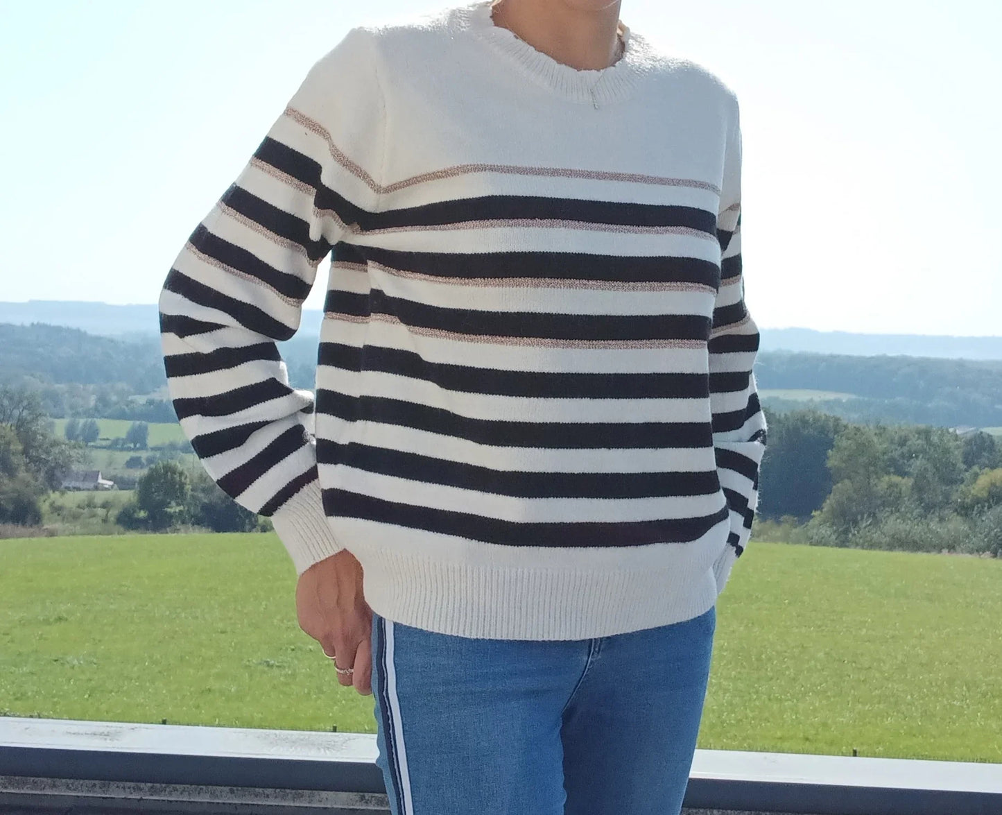 Pull fond blanc larges rayures noires avec fines rayures dorées porté avec un jean, vue extérieure