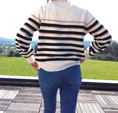 Vue de dos d'un pull fond blanc larges rayures noires avec fines rayures dorées, porté avec un jean bleu