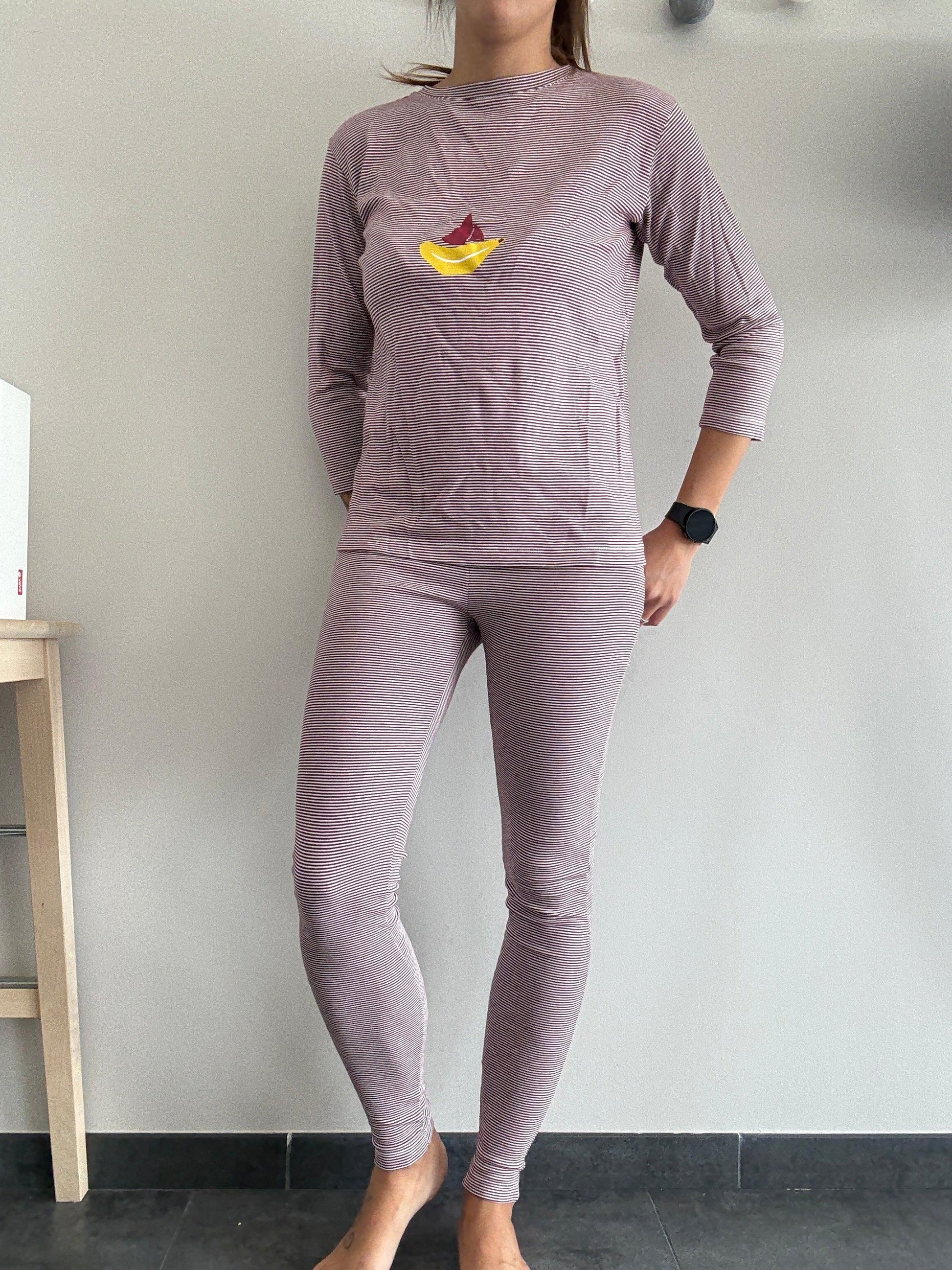 Woman wearing long-sleeve striped purple pyjama set with fruit design, Le Petit Placard