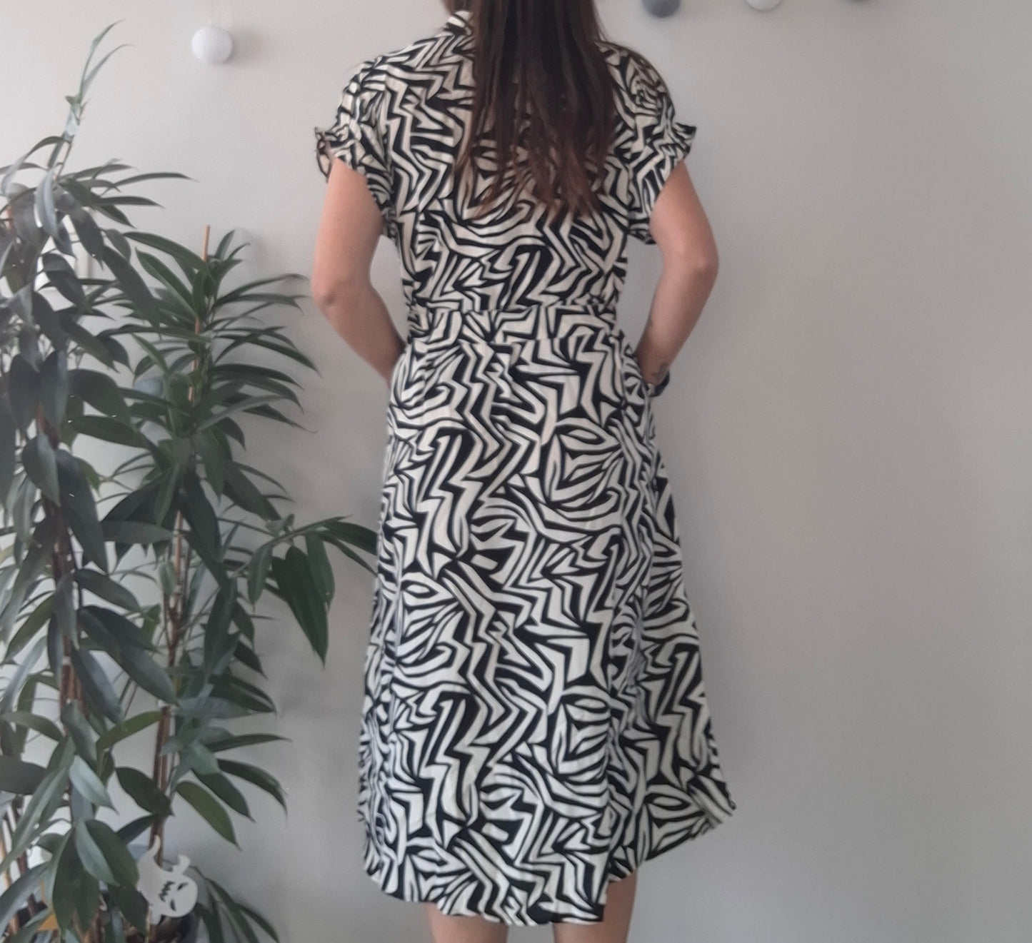 Woman in black and white patterned dress, Le Petit Placard boutique fashion, indoor plant decor