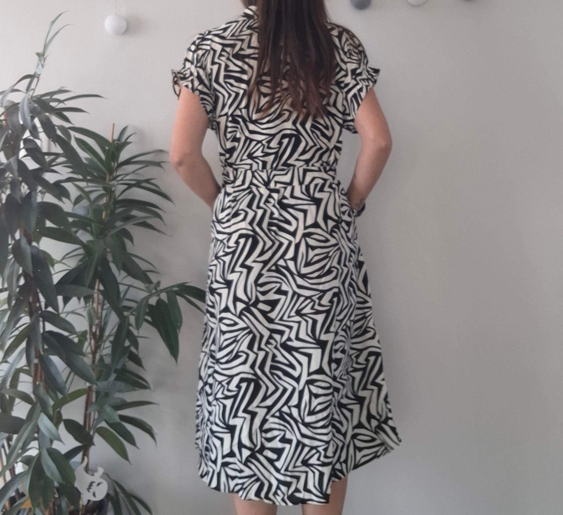 Woman in black and white patterned dress, Le Petit Placard boutique fashion, indoor plant decor