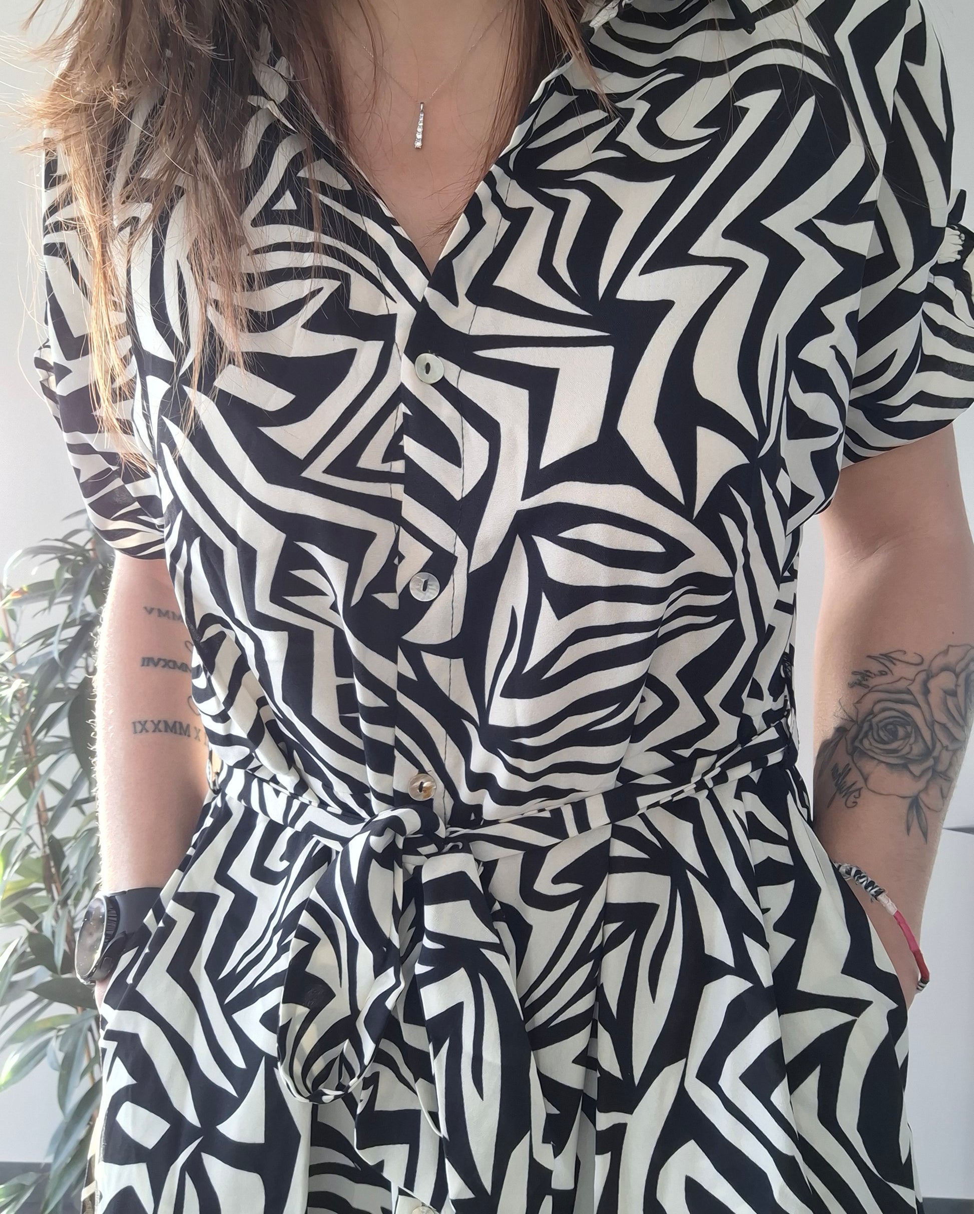 Woman wearing a black and white geometric dress, belt tied at waist, Le Petit Placard style