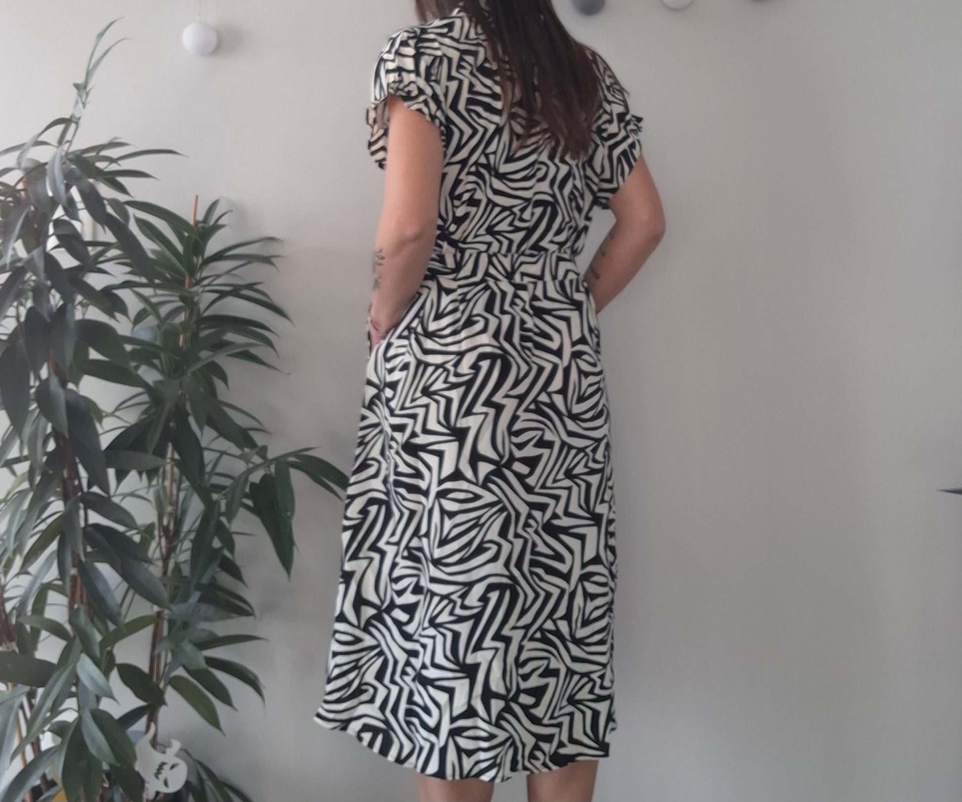 Woman wearing black and white geometric midi dress near indoor plant, Le Petit Placard fashion