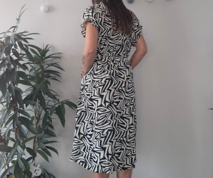 Woman wearing black and white geometric midi dress near indoor plant, Le Petit Placard fashion