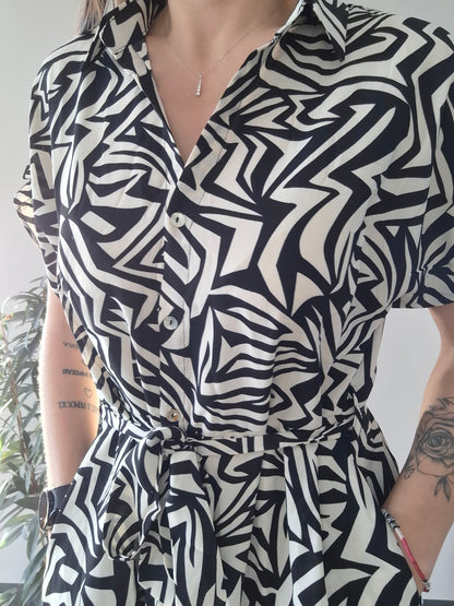Woman wearing a black and white geometric print belted dress, Le Petit Placard fashion