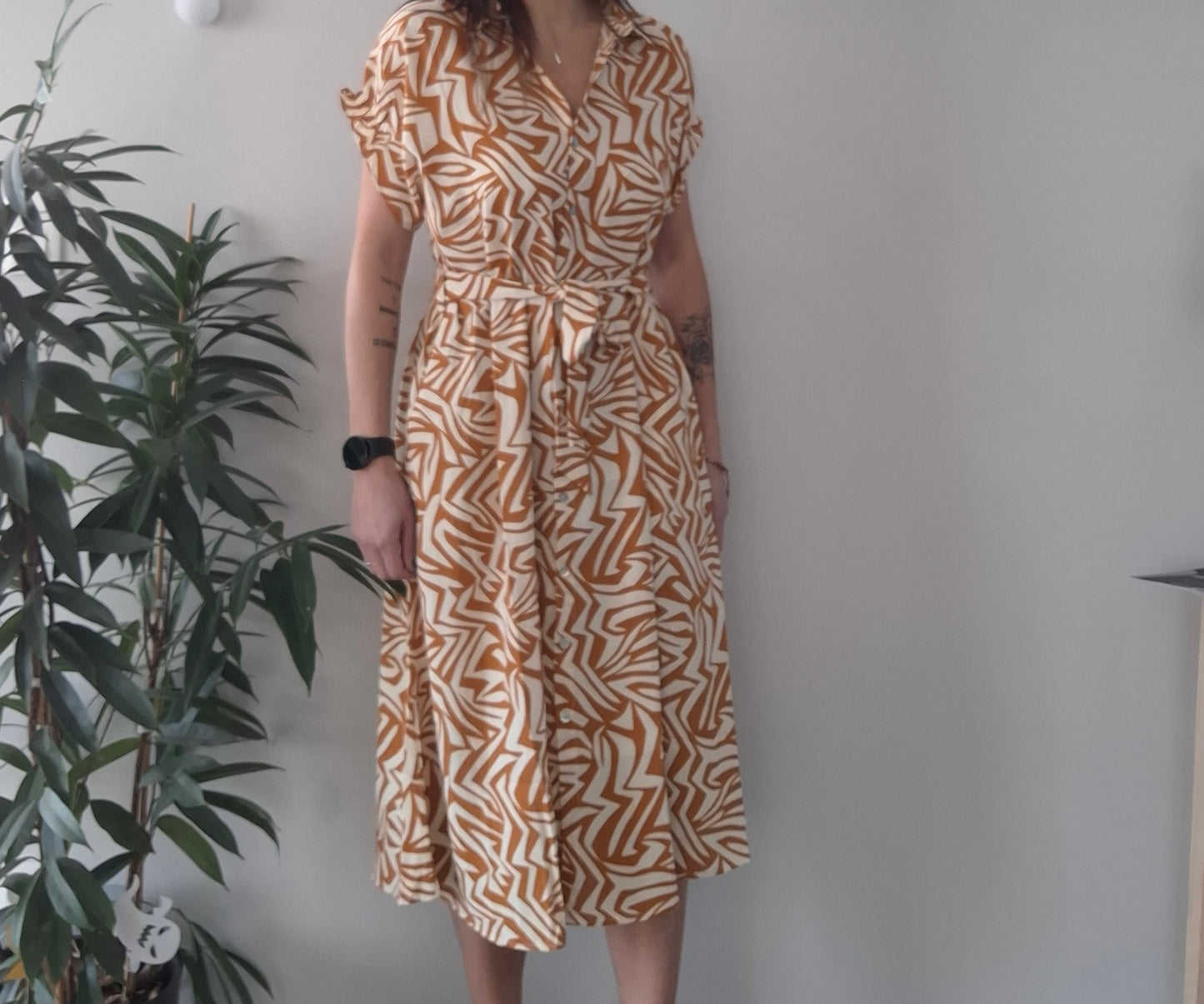 Woman wearing an orange and white patterned midi dress, Le Petit Placard fashion style