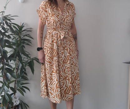 Woman wearing an orange and white patterned midi dress, Le Petit Placard fashion style
