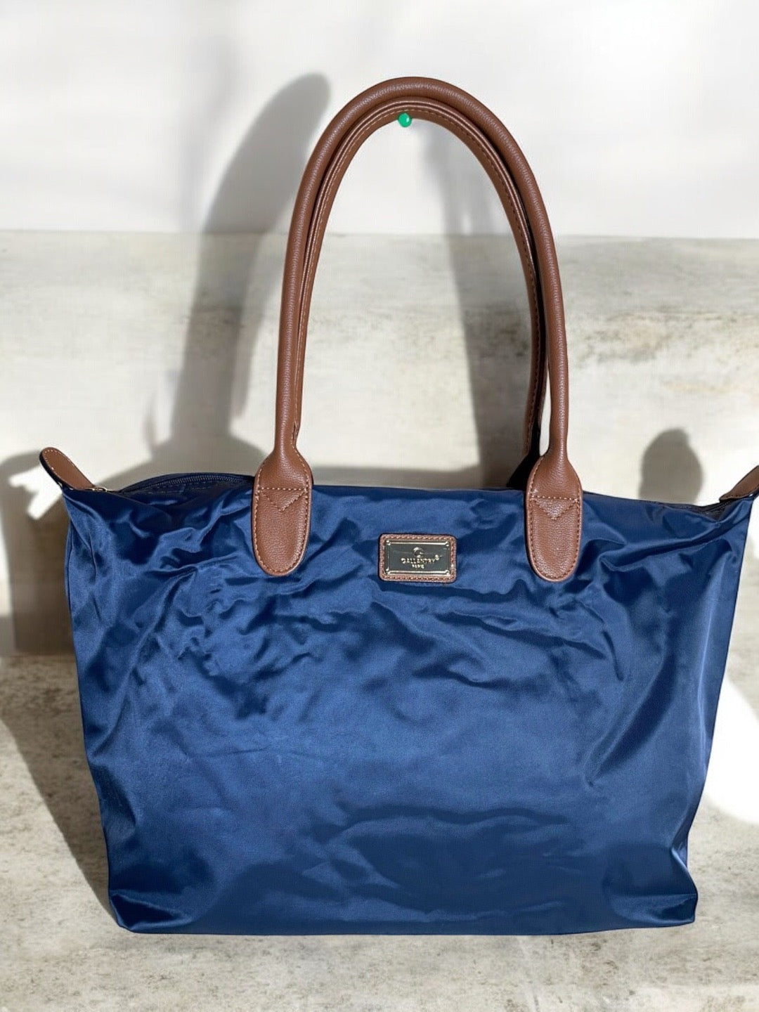 Sac à main fourre-tout bleu marine en nylon avec anses en cuir marron et plaque dorée