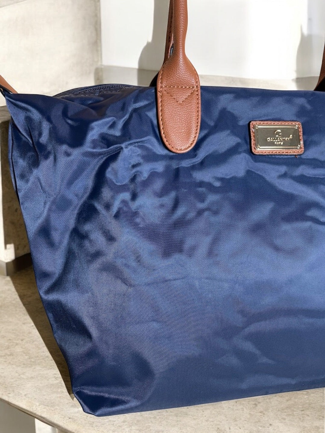 Sac à main fourre-tout bleu marine en nylon avec anses en cuir camel et plaque dorée de marque