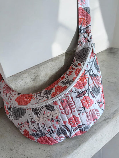 Floral quilted sac banane with zipper on a concrete surface, Le Petit Placard accessories
