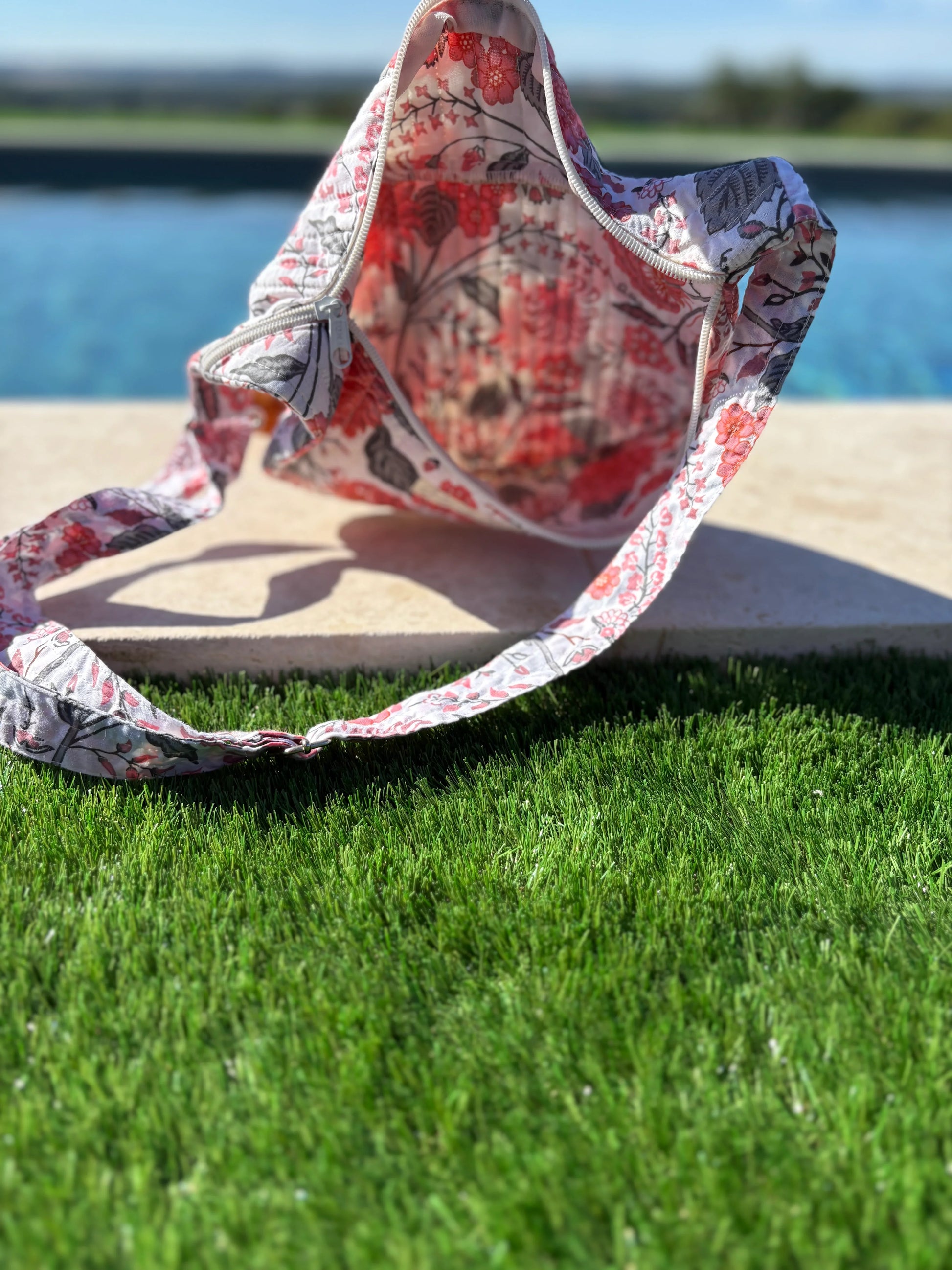 Floral fanny pack on grass by pool, trendy accessory at Le Petit Placard