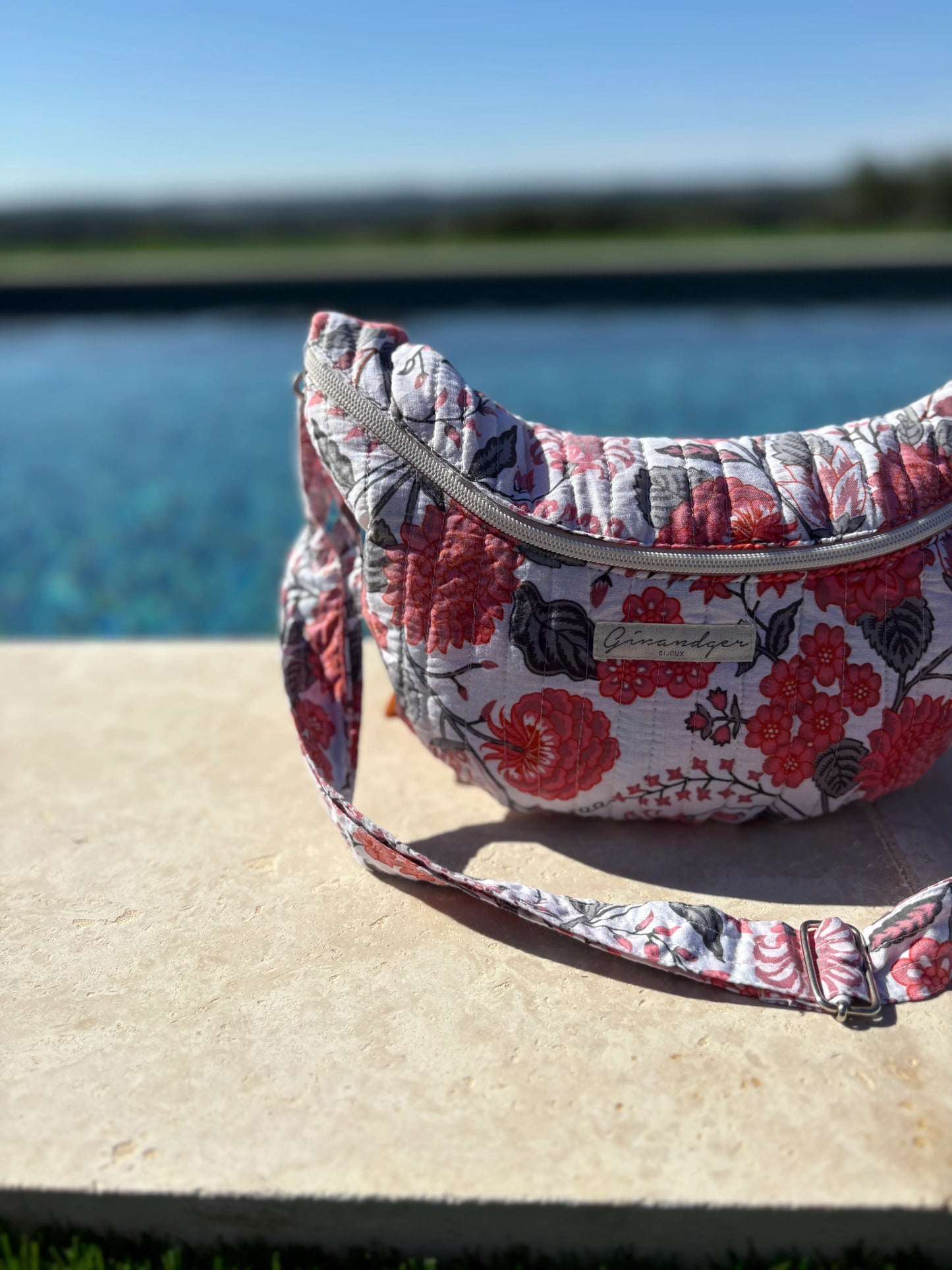 Floral quilted fanny pack on stone ledge by pool, Le Petit Placard accessory