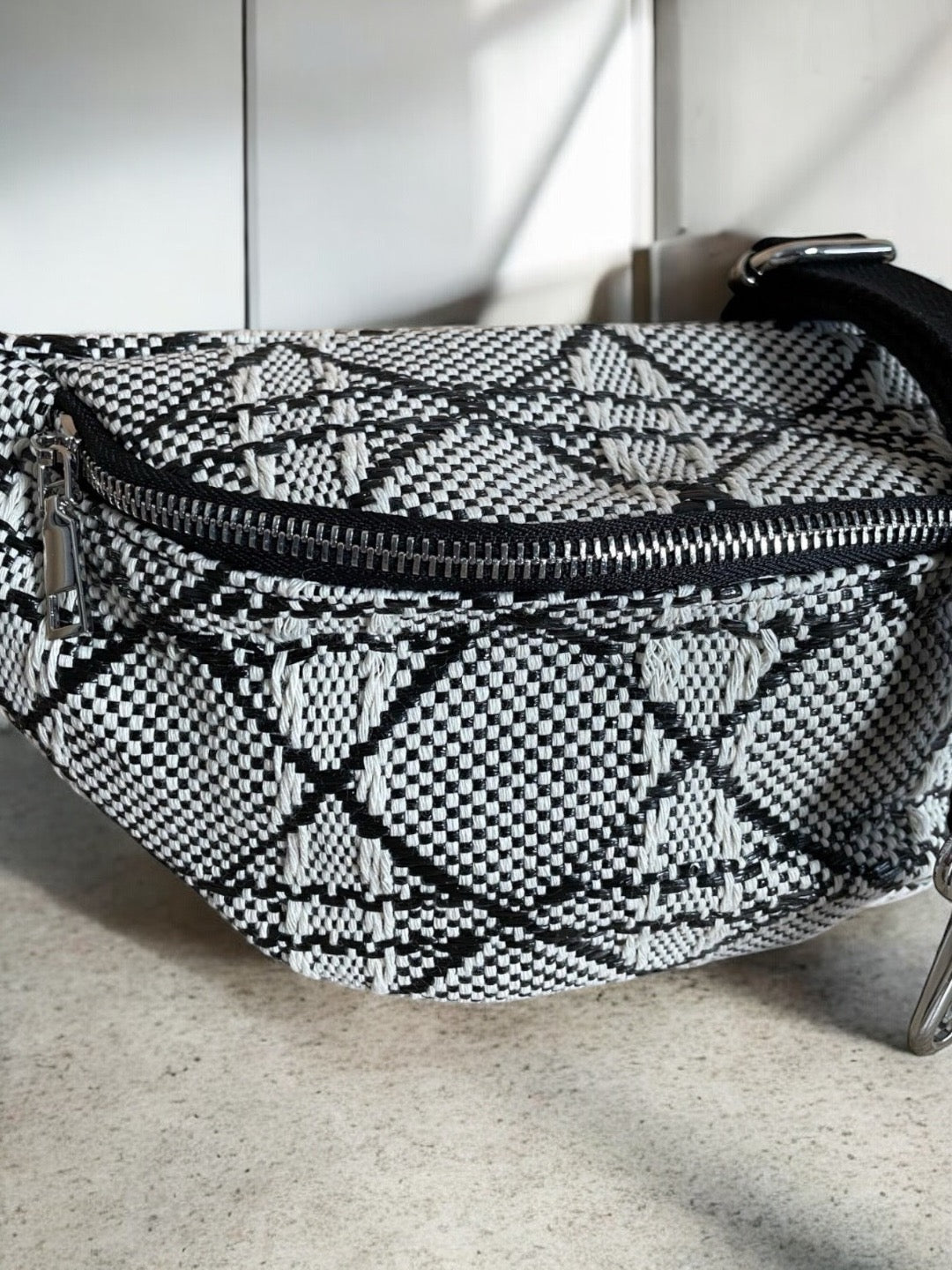 Sac banane effet tissu tressé noir et blanc avec fermeture éclair argentée et bandoulière réglable