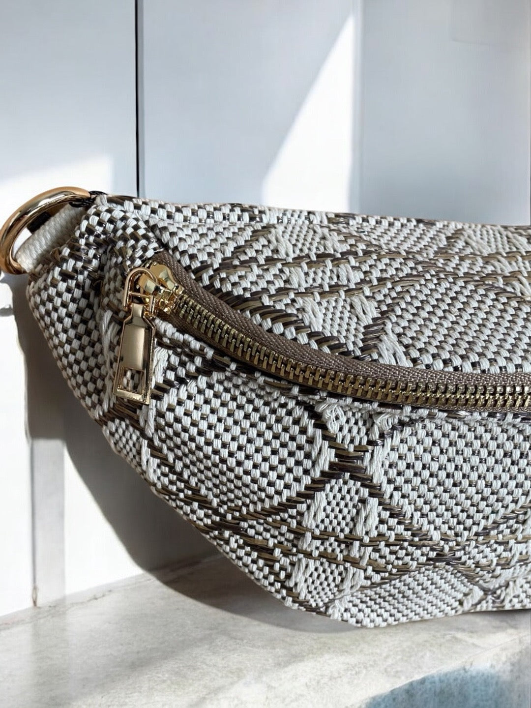Sac banane effet tissu tressé taupe et crème avec fermeture éclair dorée, vue rapprochée
