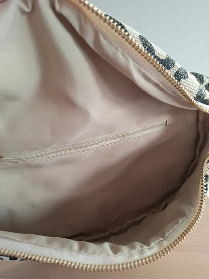 Intérieur du sac banane motif léopard noir et beige avec poche zippée dorée et doublure rose pâle