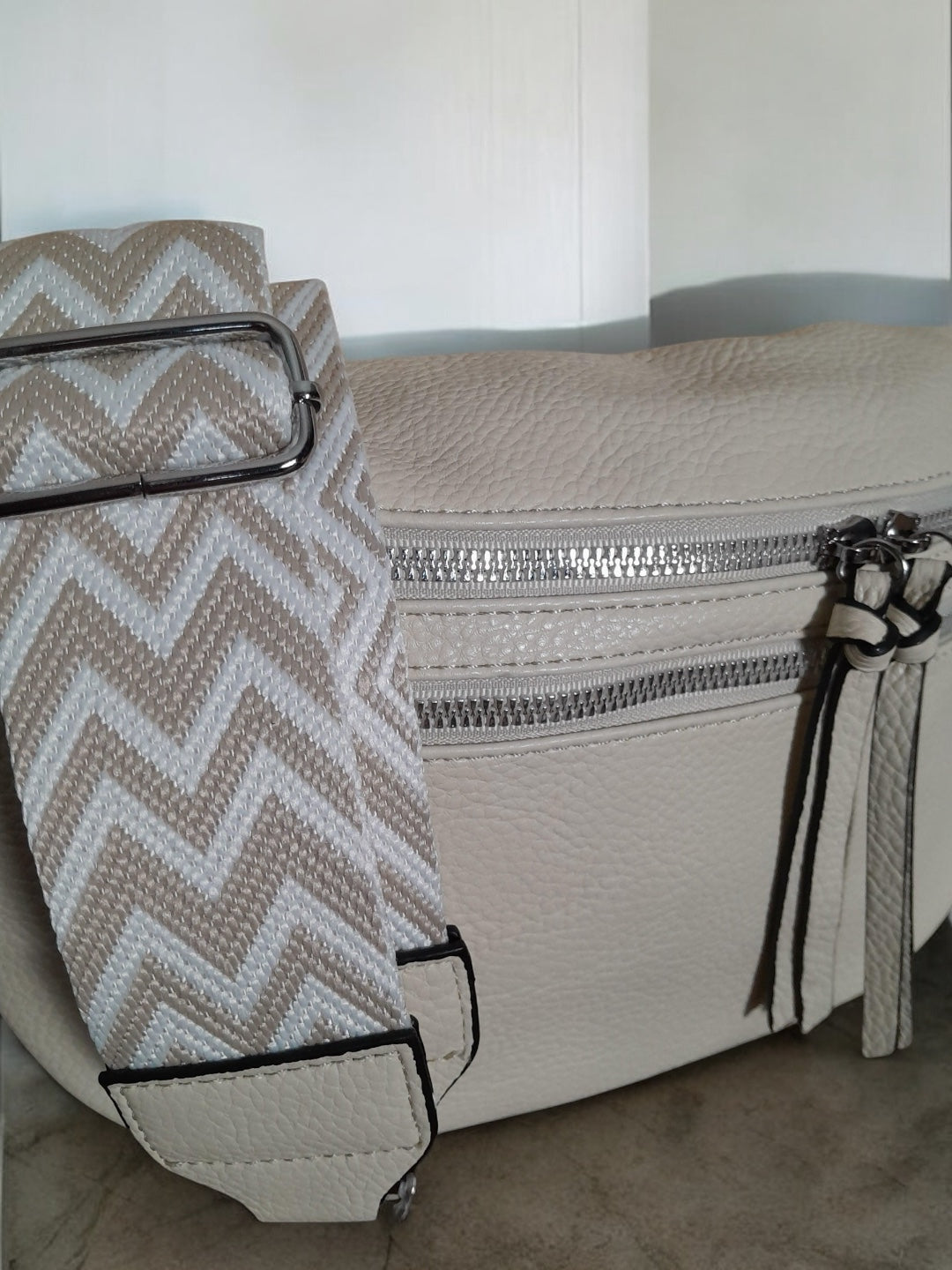 Beige faux leather bum bag with chevron strap and silver zippers from Le Petit Placard