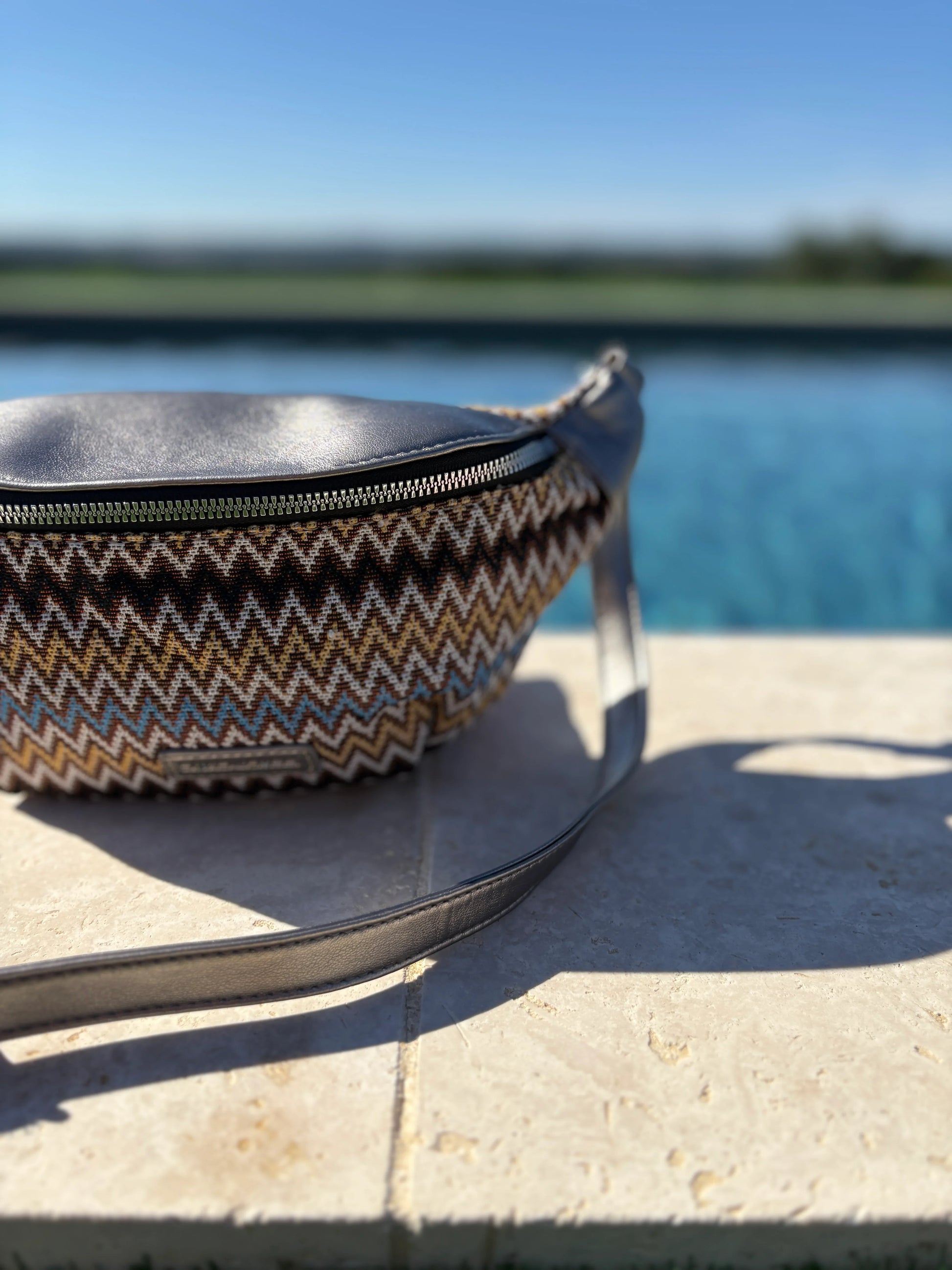 Trendy zigzag patterned sac banane on stone by a pool, Le Petit Placard accessories